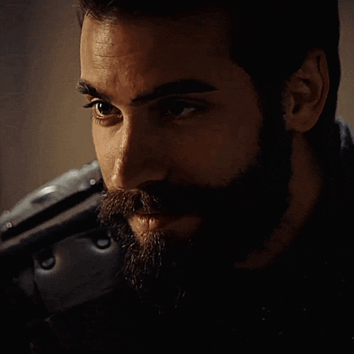 a close up of a man with a beard looking at the camera