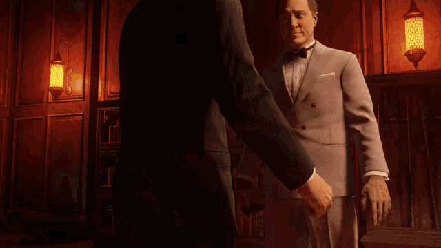 two men shaking hands in a dark room