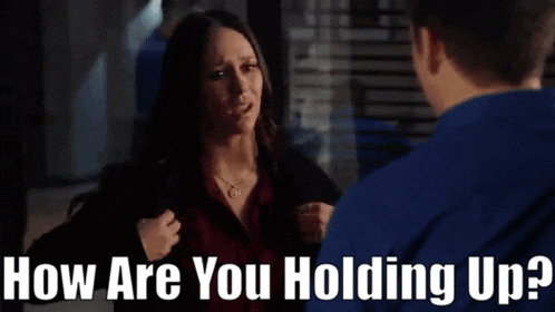 a woman is holding her chest while talking to a man who is asking her how are you holding up .