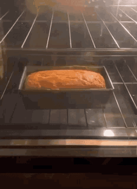 a loaf of bread is baking in a pan in an oven