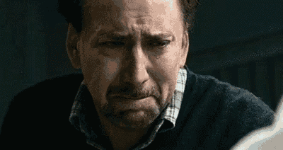a close up of a man 's face with a beard making a face .