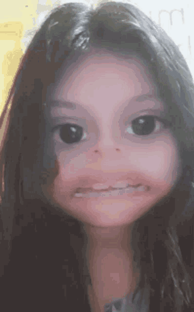 a young girl with long hair is making a funny face .