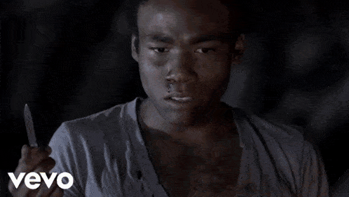 a man in a white shirt is holding a knife in his right hand