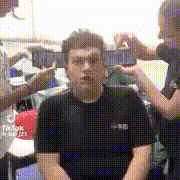 a man in a black shirt is being photographed by two women