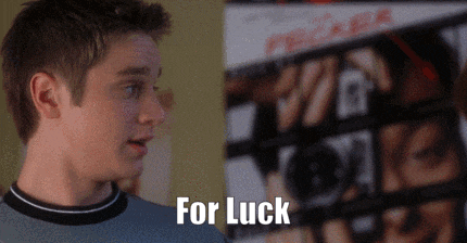 a man is standing in front of a poster that says for luck