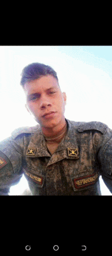 a man in a military uniform is taking a selfie with the letters g and o on the bottom