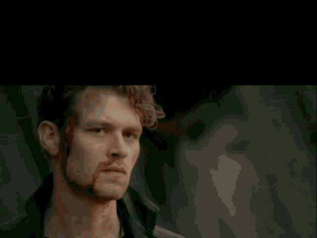 a man and a woman are standing next to each other with blood on their faces .