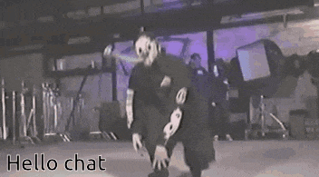 a man in a mask is dancing on a stage in a dark room .