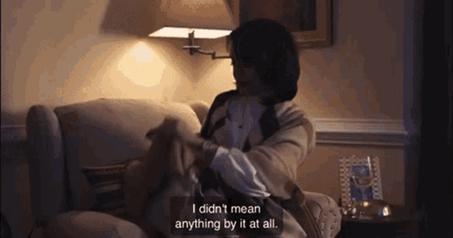 a woman is sitting on a couch and says i didn 't mean anything by it at all