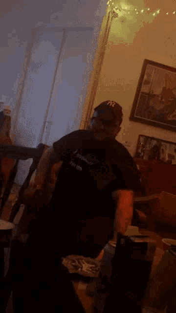 a man wearing a ny hat sits on a couch with a woman