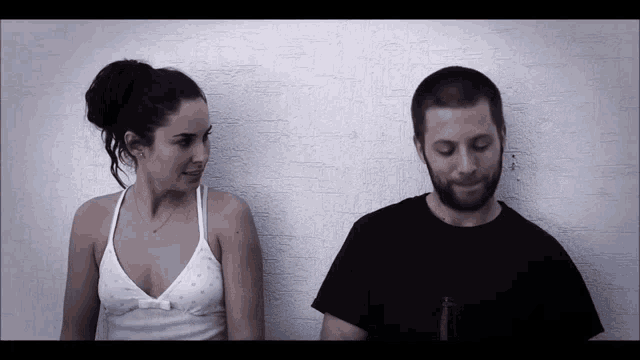 a man and a woman are standing next to each other looking at each other