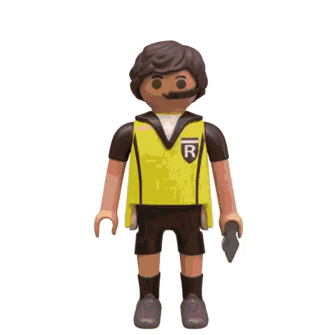 a playmobil figure of a referee is holding a red card in his hand .