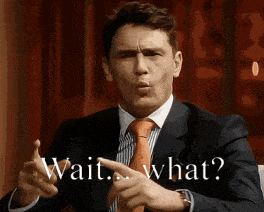 a man in a suit and tie is pointing at the words wait what