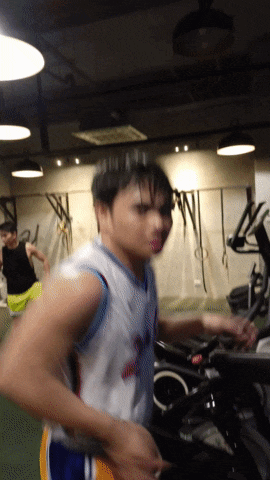 a man wearing a jersey that says ' warriors ' on it is running on an exercise bike