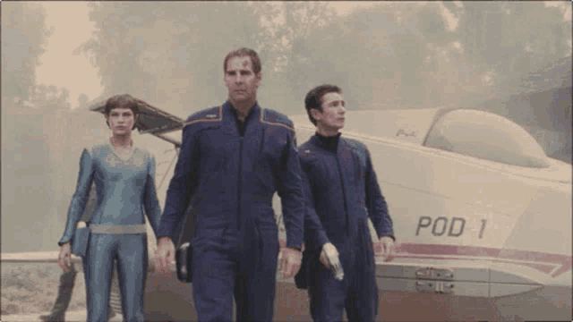 three people walking in front of a pod 1