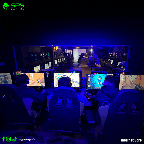 a group of people are playing a video game in a spy gaming cafe