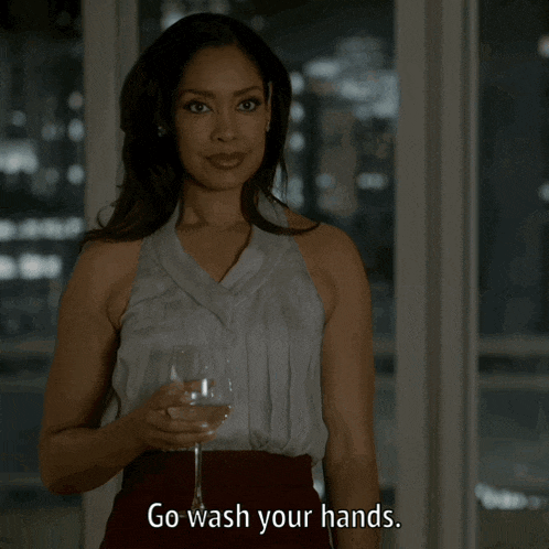 a woman is holding a glass of wine and saying go wash your hands
