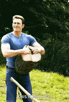 a man in a blue shirt is holding a log and a shovel .