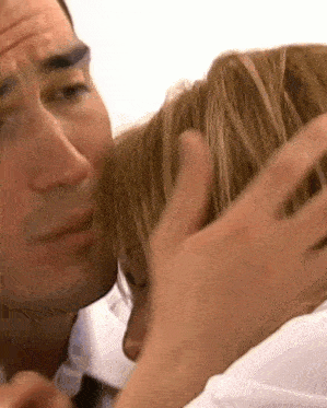 a man is kissing a woman on the forehead in a close up .
