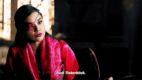 a woman with a blindfold on her eye is sitting in a chair and says `` fuck tinkerbitch '' .