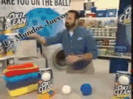 a man is standing in front of a washing machine with the words " are you on the ball " written on the wall behind him