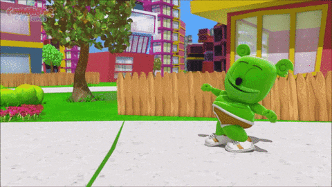 a green gummy bear is dancing on a sidewalk in a cartoon scene