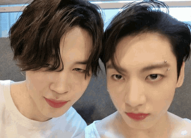 two young men are posing for a picture and one has a piercing in his eye