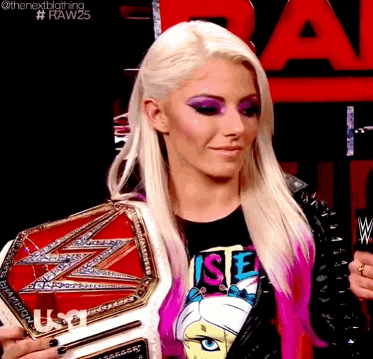 a woman is holding a wrestling championship belt and wearing a t-shirt with the word justice on it
