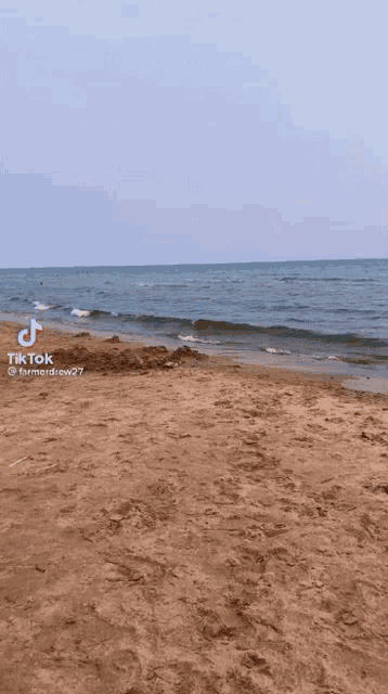 a tik tok video of a beach with a blue sky and waves