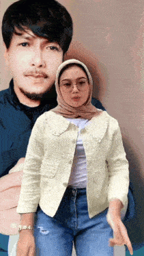 a woman wearing a hijab and glasses stands in front of a man
