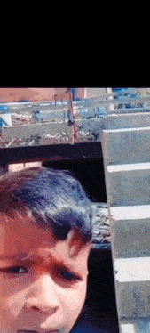 a young boy is taking a picture of himself in front of a staircase .