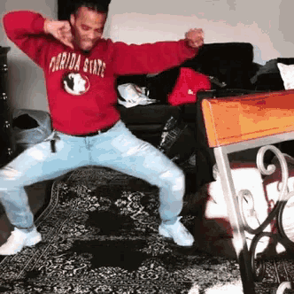 a man wearing a red florida state sweatshirt is dancing