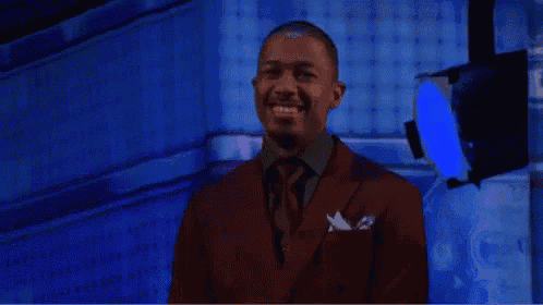 a man in a red suit is smiling in front of a blue light