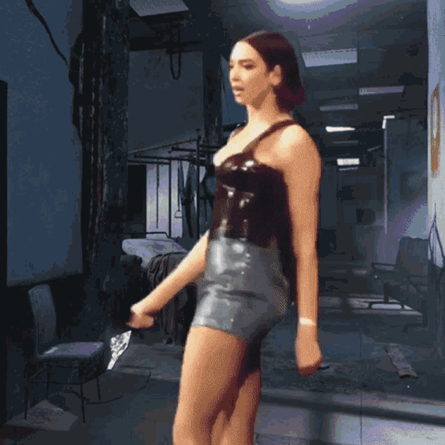 a woman is holding a gun in a dark hallway
