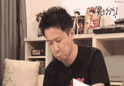 a man is sitting at a desk with a pc engine in the background