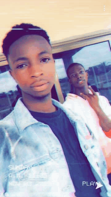 two young men are posing for a picture and one of them is wearing a denim jacket