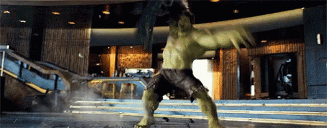 a hulk is standing in front of a building with stairs in the background