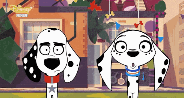 two dalmatian dogs are standing next to each other in front of a building that says disney premiere