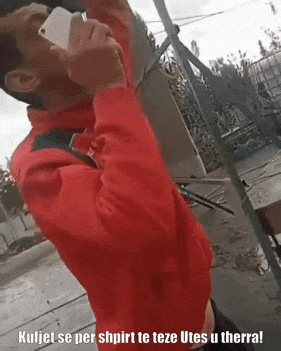 a man in a red jacket is talking on his phone