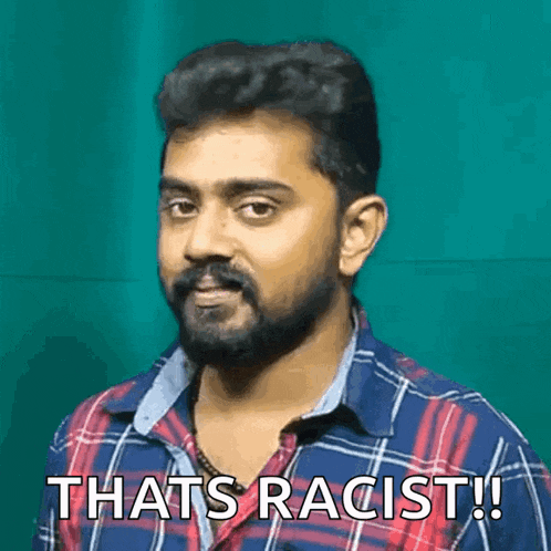 a man with a beard wearing a plaid shirt is saying that 's racist !