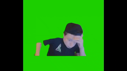 a man in a hat is sitting in front of a green screen .