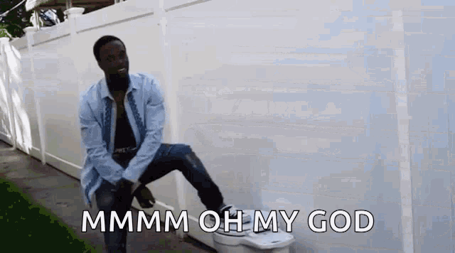 a man is sitting on top of a toilet with the words `` mmmm oh my god '' written on it .