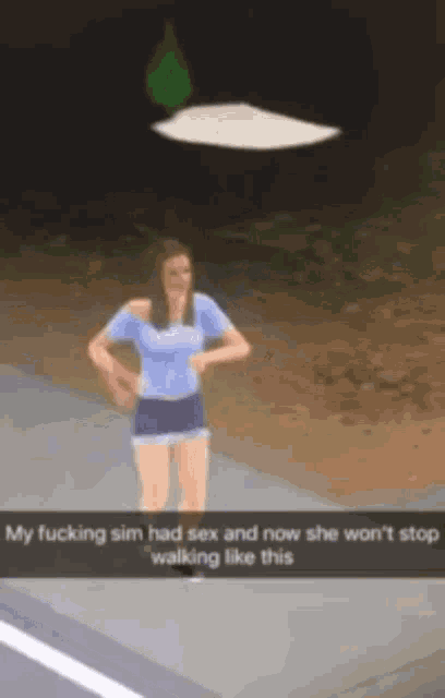 a woman in a blue shirt and shorts is standing on a sidewalk with a flying object in the background