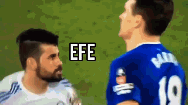 a man in a blue shirt with the number 19 on it talks to another man