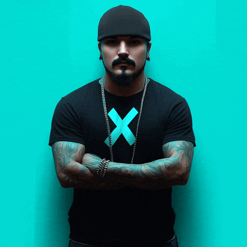 a man with a beard wearing a black shirt with an x on it