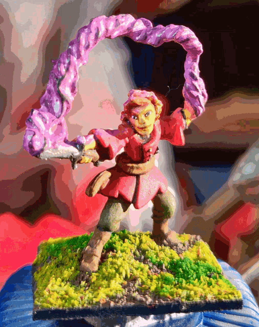 a statue of a man in a red coat holding a sword and a purple object