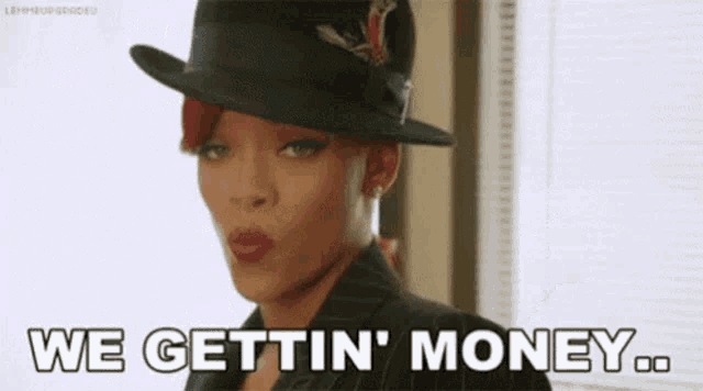 a woman wearing a hat and a suit is saying `` we gettin ' money ... ''