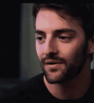 a close up of a man 's face with a beard .