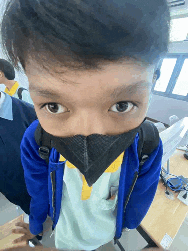 a young boy wearing a mask and a blue jacket