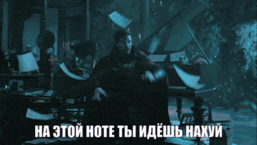 a man in a red cape stands in front of a piano with a foreign language caption